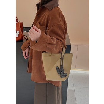 Geantă bucket din piele naturală cu închidere magnetică, textură moale, buzunare interne pentru telefon și card de identificare, design urban minimalist