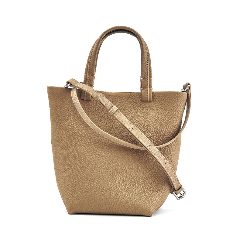 Geantă bucket din piele naturală cu închidere magnetică, textură moale, buzunare interne pentru telefon și card de identificare, design urban minimalist