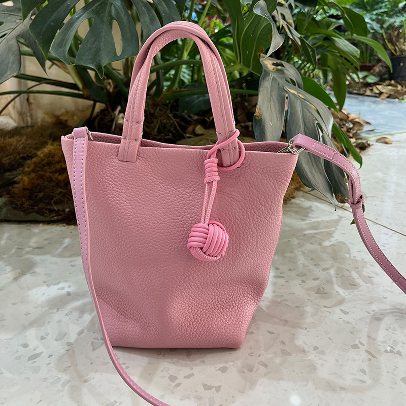 Geantă bucket din piele naturală cu închidere magnetică, textură moale, buzunare interne pentru telefon și card de identificare, design urban minimalist