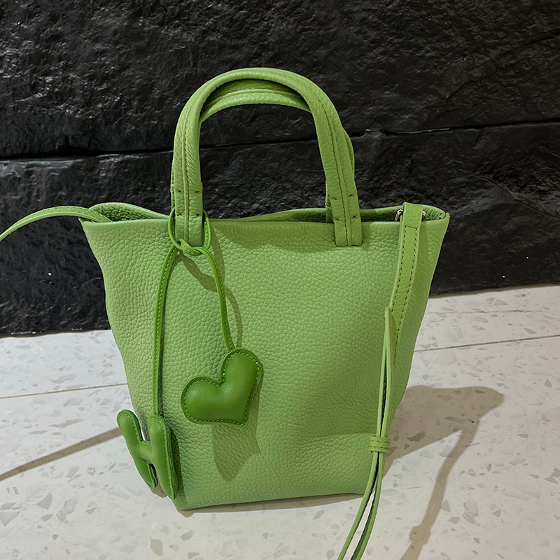 Geantă bucket din piele naturală cu închidere magnetică, textură moale, buzunare interne pentru telefon și card de identificare, design urban minimalist