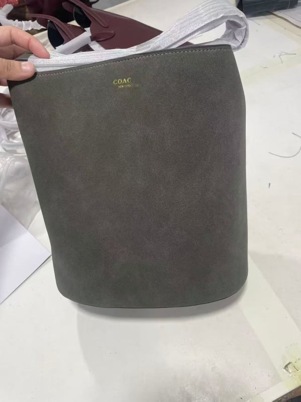 Geantă tip găleată din piele de vițel, cu o singură curea, căptușeală poliester, închidere snap, buzunare interioare: fermoar, pentru telefon și documente, stil retro, lansată în iarna 2025