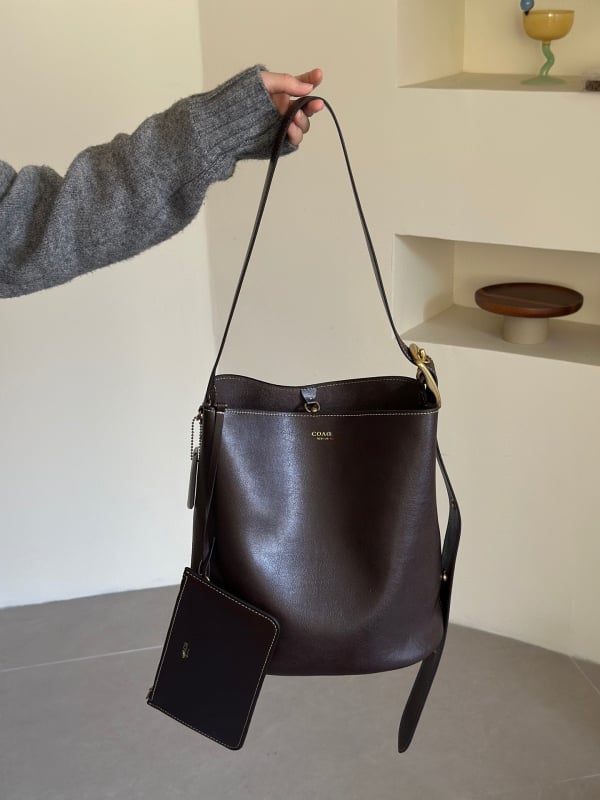 Geantă tip găleată din piele de vițel, cu o singură curea, căptușeală poliester, închidere snap, buzunare interioare: fermoar, pentru telefon și documente, stil retro, lansată în iarna 2025