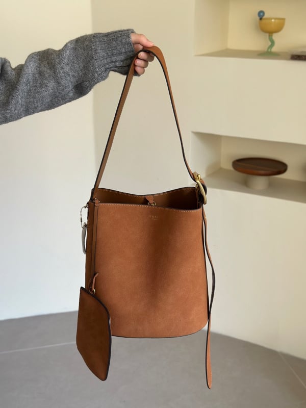 Geantă tip găleată din piele de vițel, cu o singură curea, căptușeală poliester, închidere snap, buzunare interioare: fermoar, pentru telefon și documente, stil retro, lansată în iarna 2025