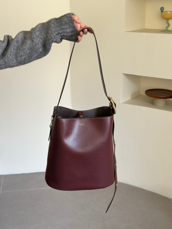 Geantă tip găleată din piele de vițel, cu o singură curea, căptușeală poliester, închidere snap, buzunare interioare: fermoar, pentru telefon și documente, stil retro, lansată în iarna 2025