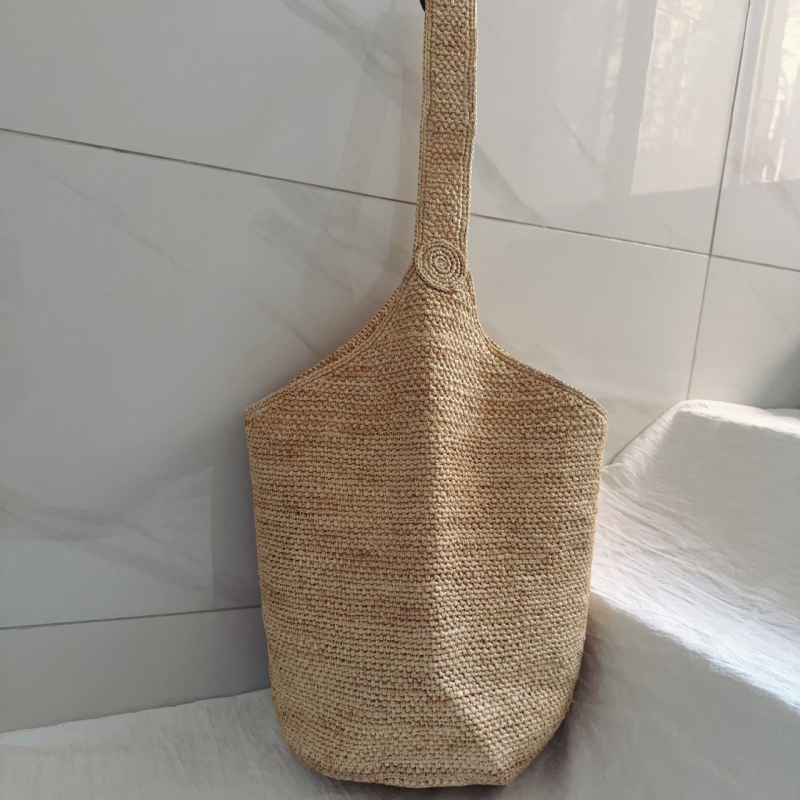 Bucket torba od rafije, gradski minimalistički stil, ovalni oblik, podstava od rafije, s jednom naramenicom
