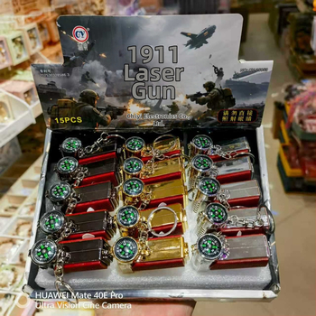 Viacfunkčná hračková pištoľ s LED osvetlením, infračerveným laserom a príveskom s kompasom; plastová konštrukcia, od 14 rokov, interaktívna hračka