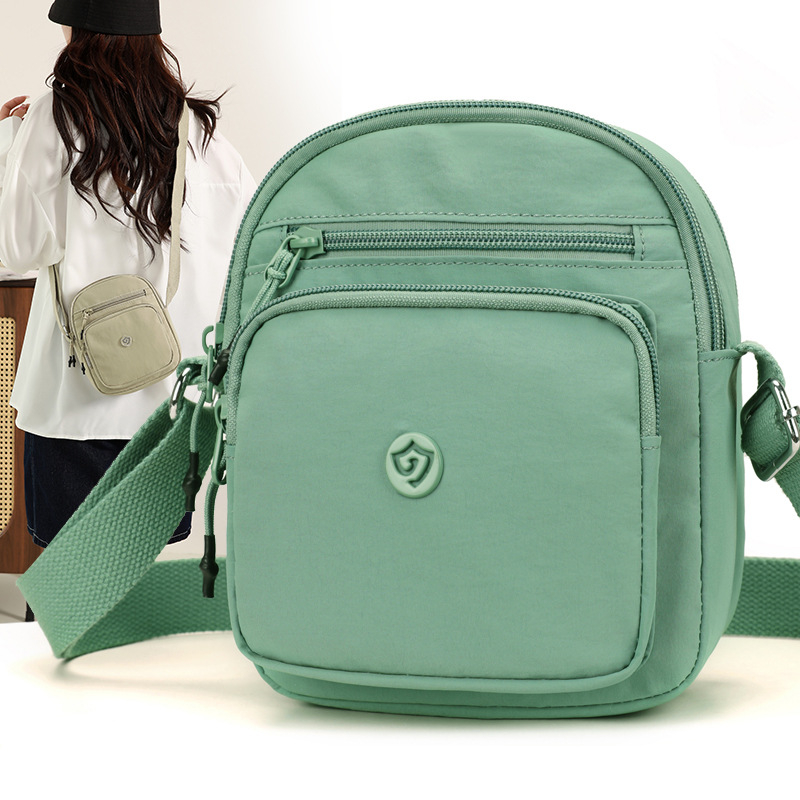 Найлонова кроссбоди чанта с вертикална квадратна форма, цип за затваряне, джоб за мобилен телефон и вътрешен джоб-патч.
