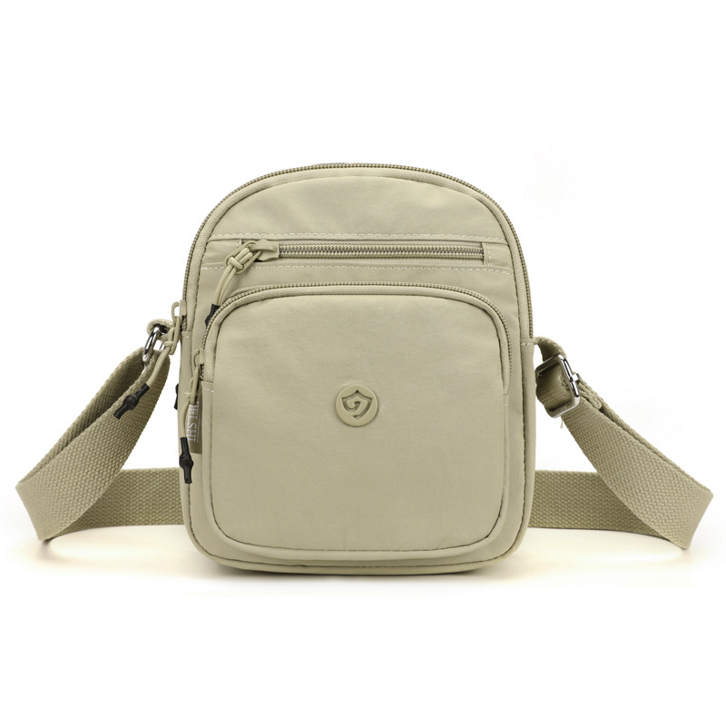 Найлонова кроссбоди чанта с вертикална квадратна форма, цип за затваряне, джоб за мобилен телефон и вътрешен джоб-патч.
