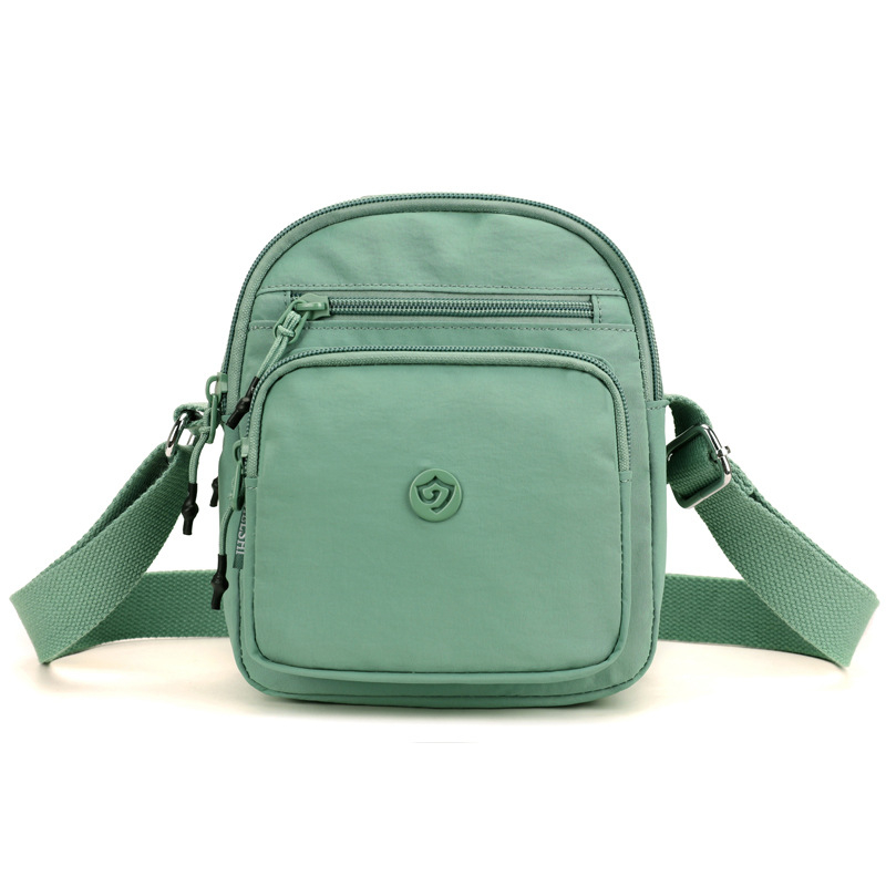 Найлонова кроссбоди чанта с вертикална квадратна форма, цип за затваряне, джоб за мобилен телефон и вътрешен джоб-патч.