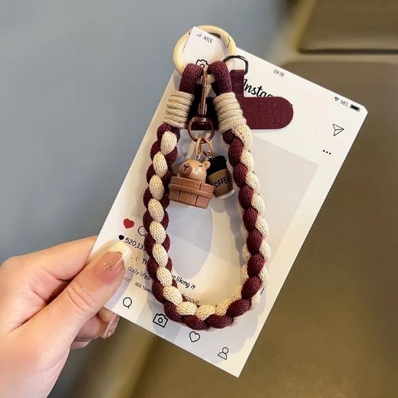 Kézzel készített telefontartó zsinór nylon fonallal, fém csattal és gumiból készült medállal állat formában