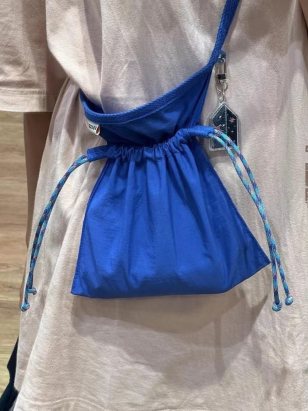 Crossbody torba s osvježavajućim i slatkim stilom, najlon materijal, zatvaranje šnuralom, unutarnji džep za mobitel.