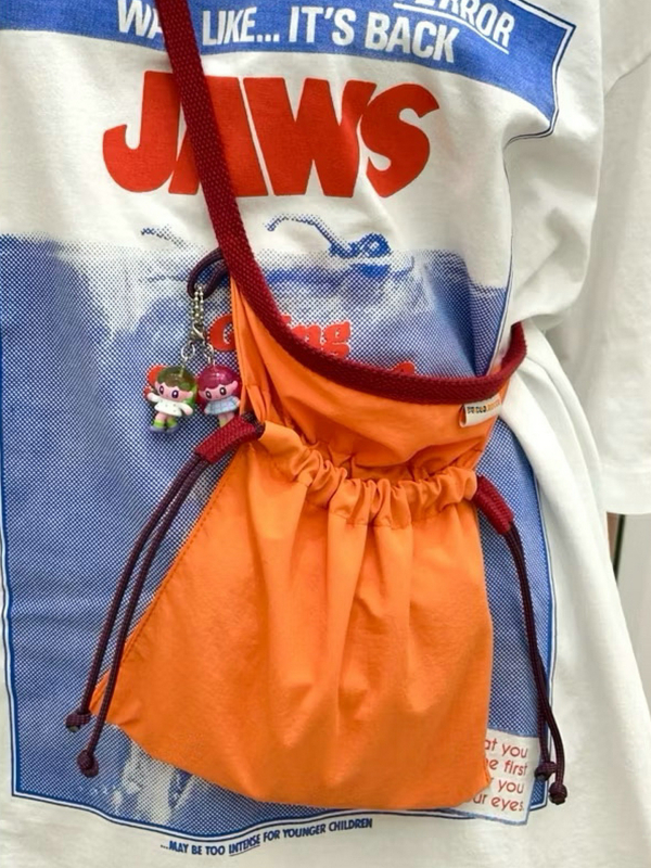 Crossbody torba s osvježavajućim i slatkim stilom, najlon materijal, zatvaranje šnuralom, unutarnji džep za mobitel.