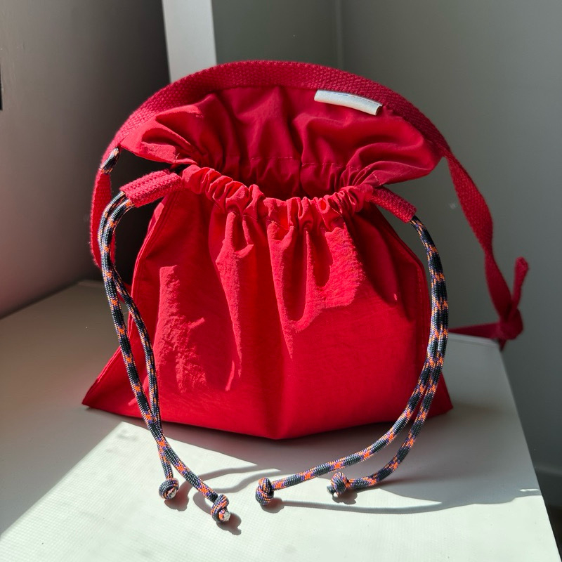 Crossbody torba s osvježavajućim i slatkim stilom, najlon materijal, zatvaranje šnuralom, unutarnji džep za mobitel.