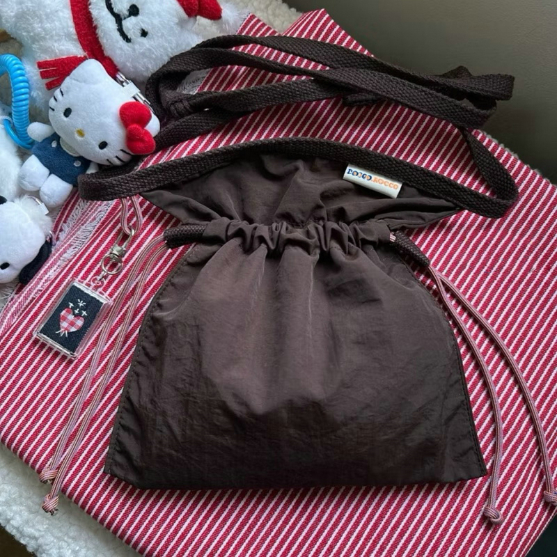 Crossbody torba s osvježavajućim i slatkim stilom, najlon materijal, zatvaranje šnuralom, unutarnji džep za mobitel.