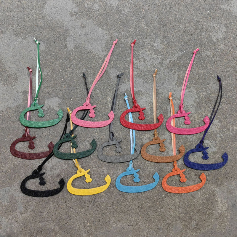 Moterų rankinės pakabukas iš natūralios odos su arabų raide (natūrali oda; arabų raidė; rankinei)