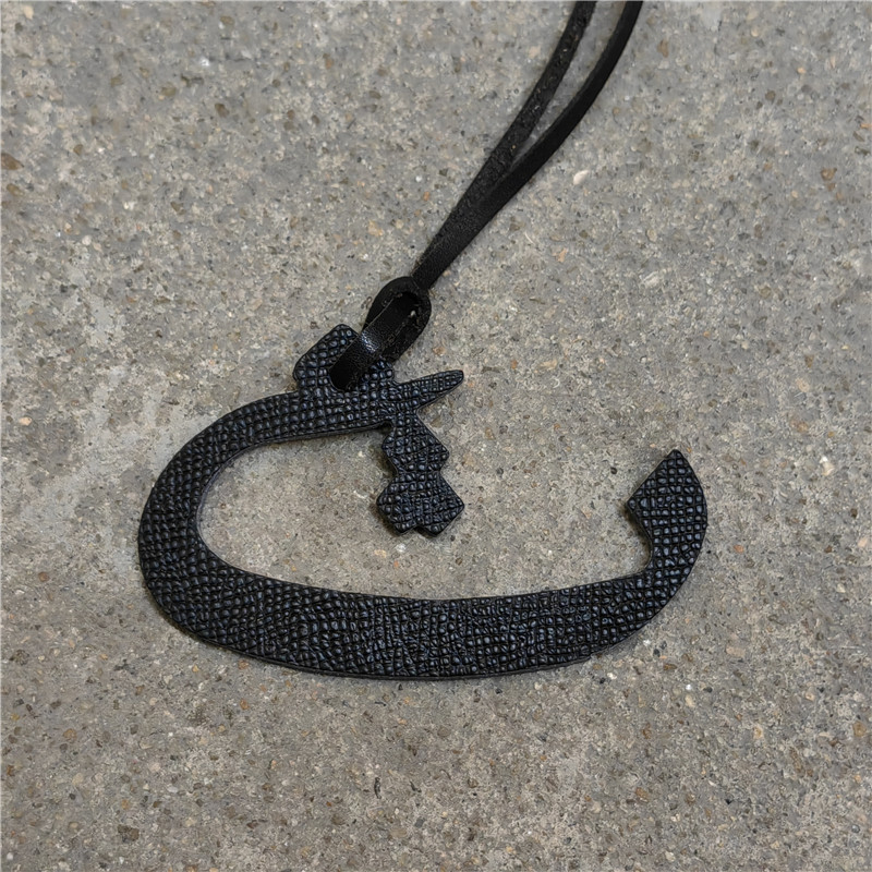 Moterų rankinės pakabukas iš natūralios odos su arabų raide (natūrali oda; arabų raidė; rankinei)