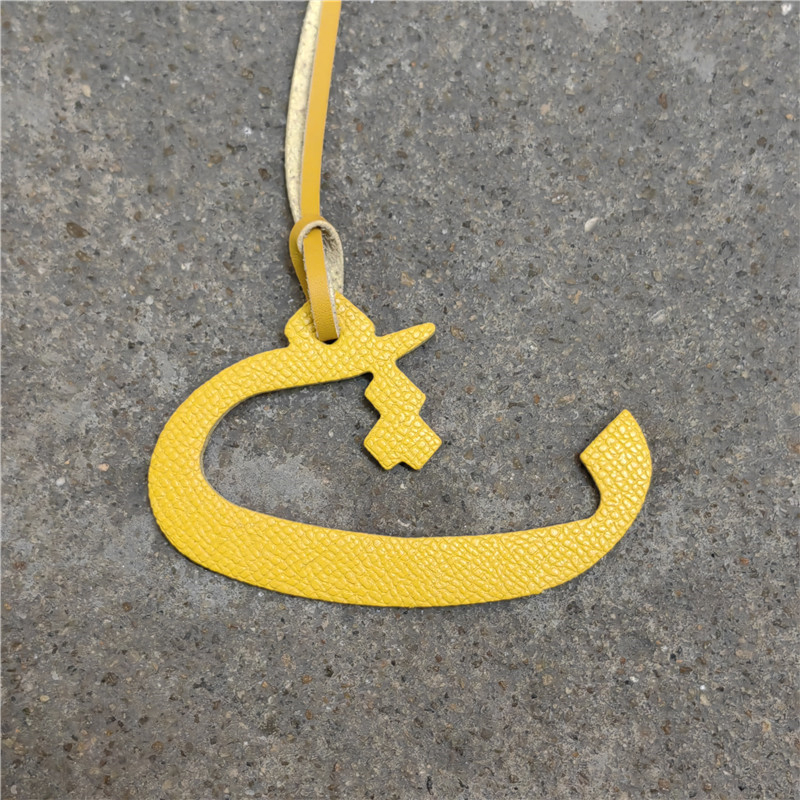 Moterų rankinės pakabukas iš natūralios odos su arabų raide (natūrali oda; arabų raidė; rankinei)