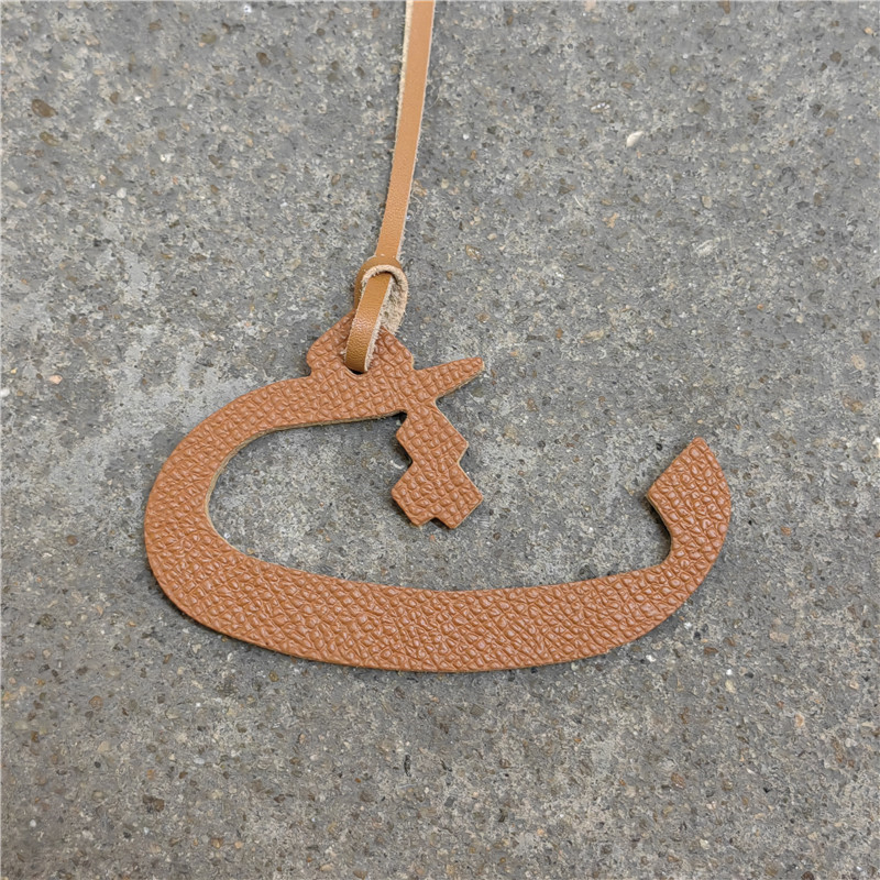 Moterų rankinės pakabukas iš natūralios odos su arabų raide (natūrali oda; arabų raidė; rankinei)