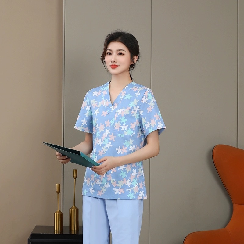 Uniformă florală de îngrijire medicală, set din două piese cu mâneci lungi, sacou cu decolteu în V și pantaloni cu șnur elastic, țesătură poliester-cotton, absorbție umidă, pentru spitale și clinici