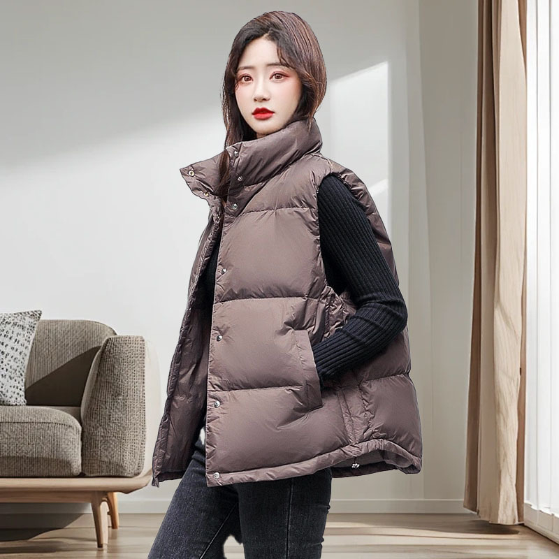 Sieviešu pūkve vestes ar stāvošu apkakli un paslēgtu pogu uzliku, bieza poliesterā audums, 81–85% balta pīļu pūka