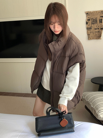 Sieviešu pūka veste ar stāvošu apkakli un rāvējslēdzēju, pūka saturs 86–90%, pildījums: baltais pīļu pūks, galvenais audums: poliesters, brīvs piegriezums, vidēja garuma, ziema 2025