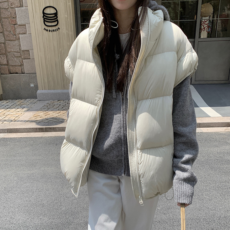 Sieviešu pūka veste ar stāvošu apkakli un rāvējslēdzēju, pūka saturs 86–90%, pildījums: baltais pīļu pūks, galvenais audums: poliesters, brīvs piegriezums, vidēja garuma, ziema 2025