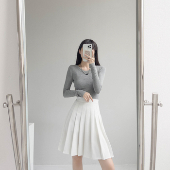 Duga plisirana suknja s elastičnim pojasom, pamuk-poliester smjesa (90–95% poliester), visoka elastičnost, gradski elegantan stil.