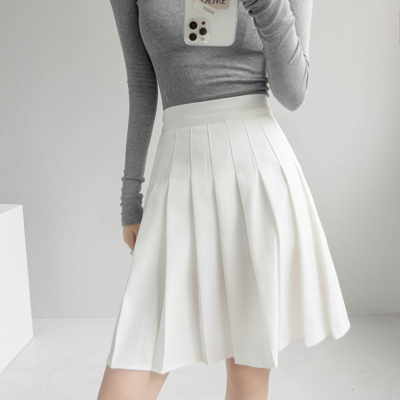 Duga plisirana suknja s elastičnim pojasom, pamuk-poliester smjesa (90–95% poliester), visoka elastičnost, gradski elegantan stil.