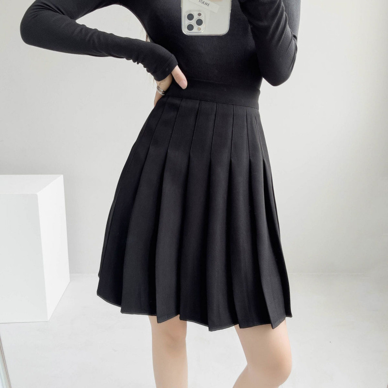 Duga plisirana suknja s elastičnim pojasom, pamuk-poliester smjesa (90–95% poliester), visoka elastičnost, gradski elegantan stil.