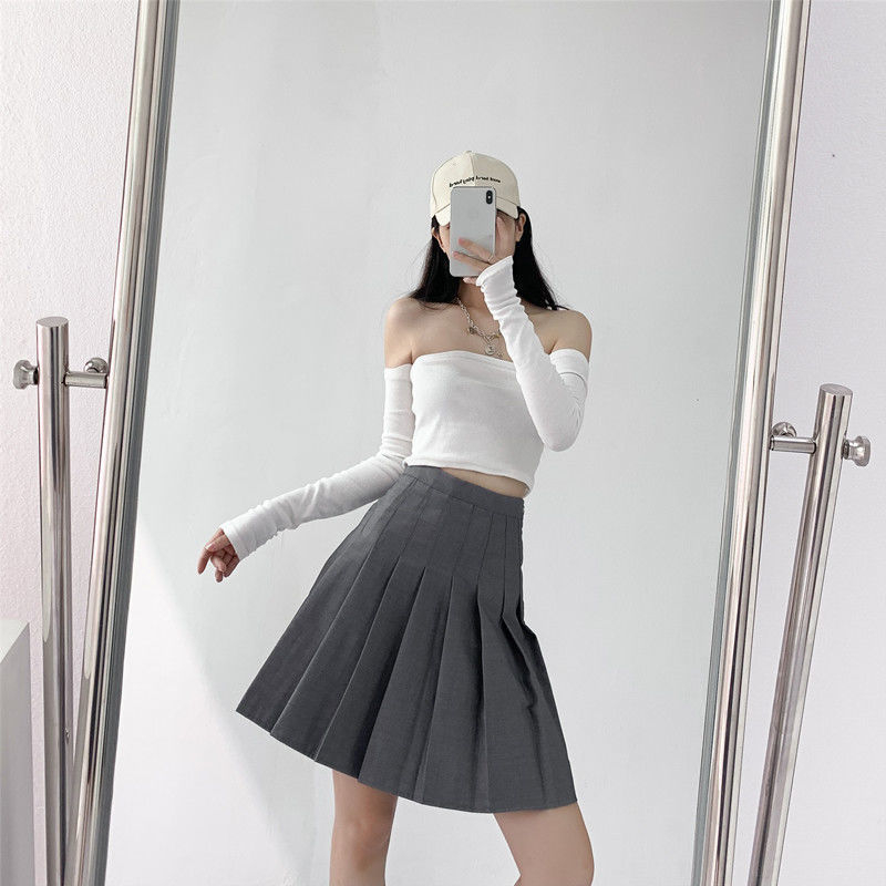 Duga plisirana suknja s elastičnim pojasom, pamuk-poliester smjesa (90–95% poliester), visoka elastičnost, gradski elegantan stil.