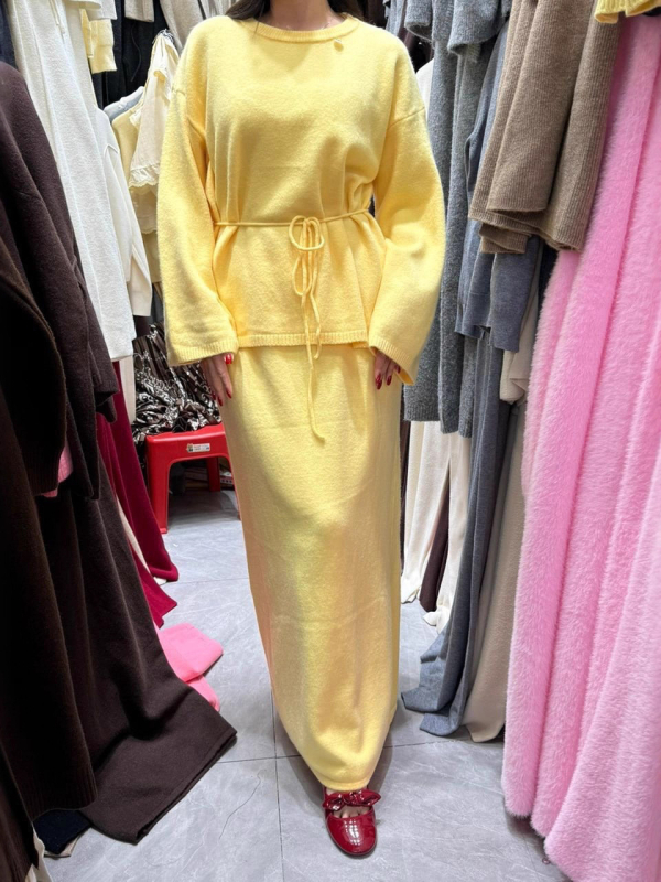 Dvostruki kostim s suknjom i puloverom: pulover s okruglim izrezom i dugim rukavima, suknja srednje duljine; smjesa akrilnih vlakana s 30–50% spandeksa; elegantan gradski stil, jesen 2025