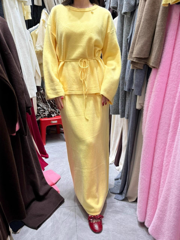Dvostruki kostim s suknjom i puloverom: pulover s okruglim izrezom i dugim rukavima, suknja srednje duljine; smjesa akrilnih vlakana s 30–50% spandeksa; elegantan gradski stil, jesen 2025
