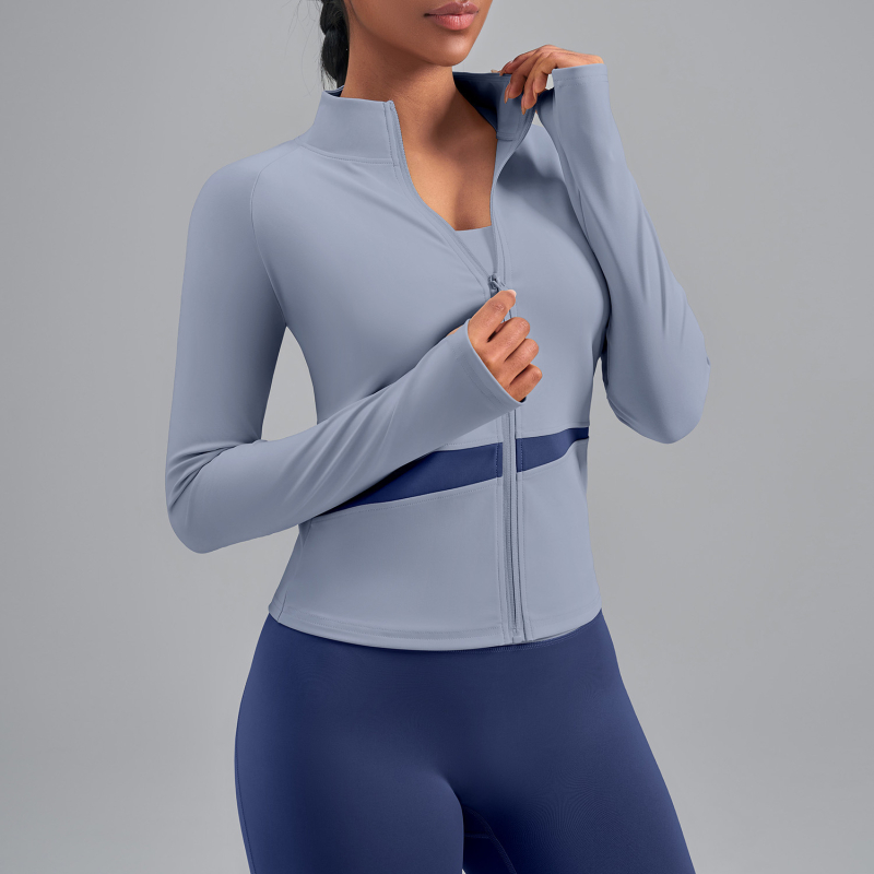 Sievietēm paredzēta persiku krāsu bloku jogas jaka ar augstu kaklu, elpojoša, atklāj vēderu, garas piedurknes, poliestera audums 82,5% — Vasara 2025