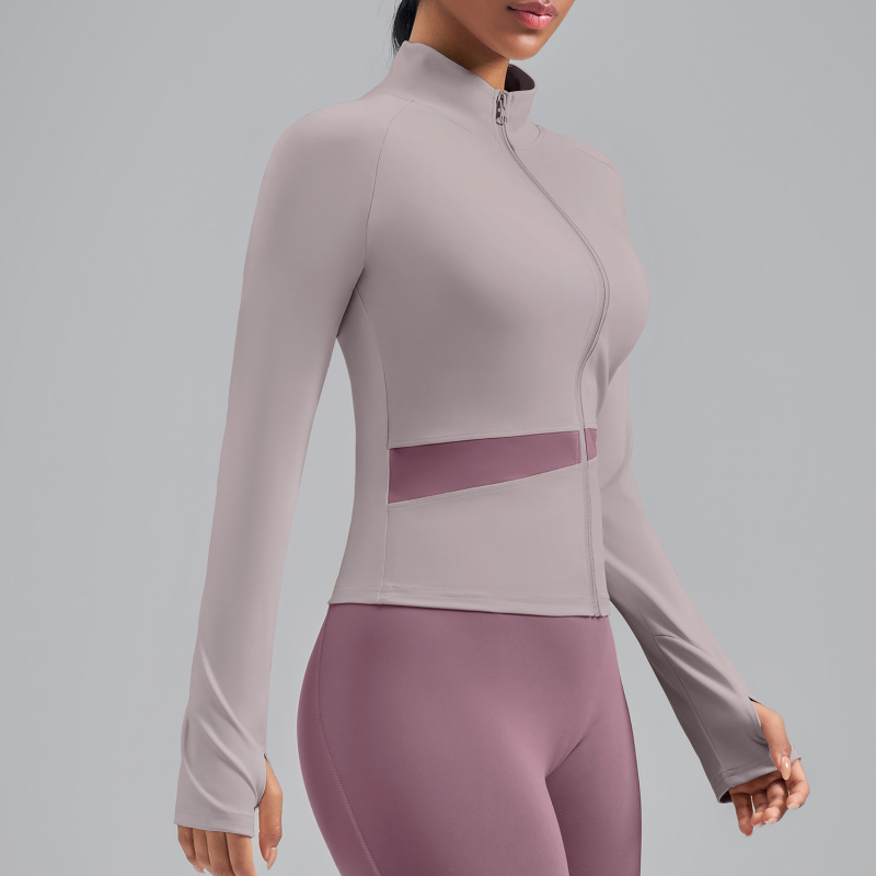 Sievietēm paredzēta persiku krāsu bloku jogas jaka ar augstu kaklu, elpojoša, atklāj vēderu, garas piedurknes, poliestera audums 82,5% — Vasara 2025
