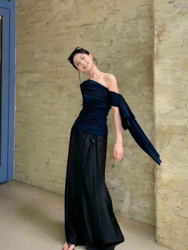 Női kötött top aszimmetrikus egyvállas kialakítással, hosszú ujjú, szabálytalan vonalú szabás, egy vonalú gallér, fő anyag tartalma 95%+