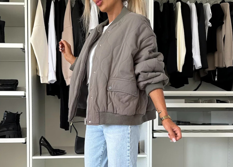 Jachetă din poliester cu spandex, croială lejeră, mâneci lungi, guler înalt, închidere cu nasturi pe un rând, lungime 50–65 cm