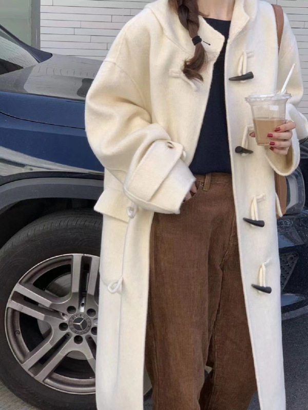 Palton damă din lână cu glugă, lungime 80–100 cm, croială lejeră, închidere cu o singură rând de catarame, 95% lână