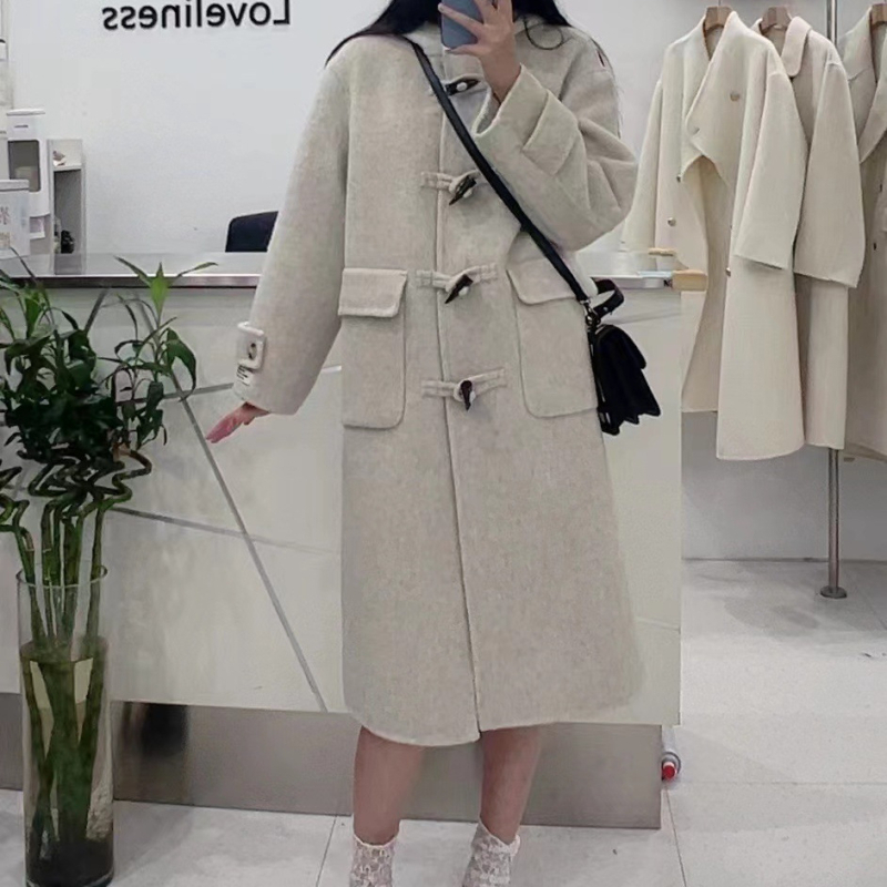 Palton damă din lână cu glugă, lungime 80–100 cm, croială lejeră, închidere cu o singură rând de catarame, 95% lână