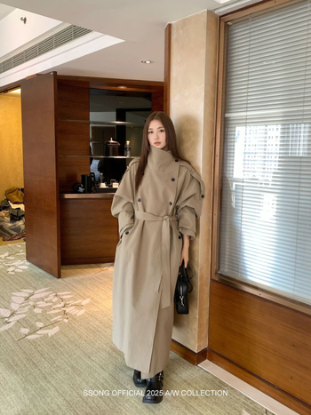 Női övvel és dupla záródású hosszú kabát ferde gallérral és zsebekkel; pamut-poliészter keverék, fő anyag: poliészter, közepes vastagság, 2025 tavasz