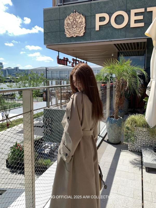 Női övvel és dupla záródású hosszú kabát ferde gallérral és zsebekkel; pamut-poliészter keverék, fő anyag: poliészter, közepes vastagság, 2025 tavasz