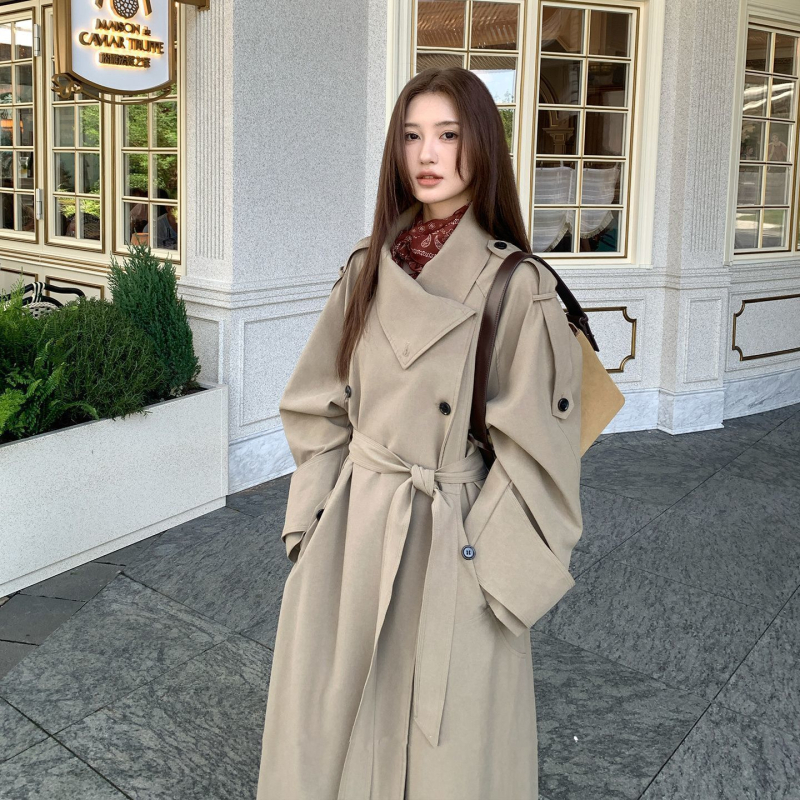 Női övvel és dupla záródású hosszú kabát ferde gallérral és zsebekkel; pamut-poliészter keverék, fő anyag: poliészter, közepes vastagság, 2025 tavasz