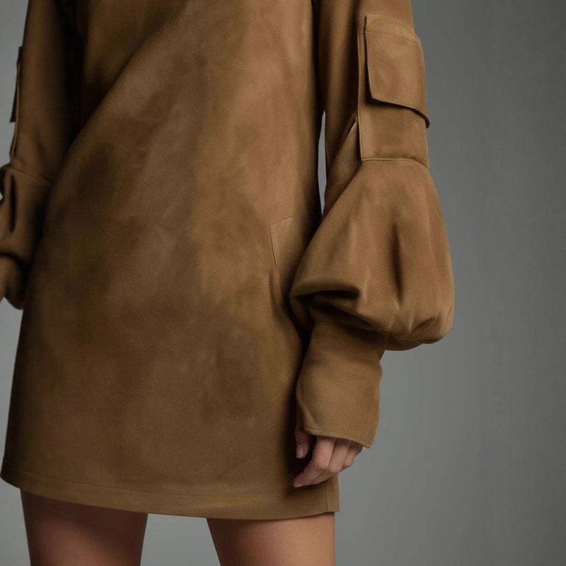 Midi haljina od suede velura s polu-visokom ovratnikom, dugi rukavi i preklopnim džepovima — elegantan stil, jesen 2025