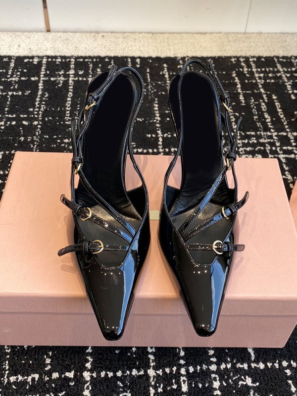 Sandale s kapom na prstima i stražnjim remenom; lakirana koža na gornjem dijelu s mašnicom; oštar vrh; uska peta 6–8 cm