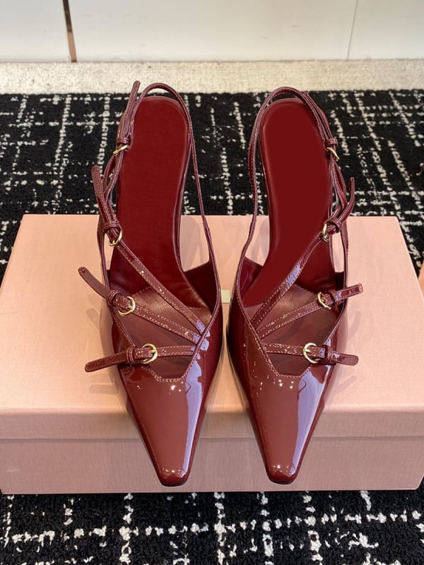 Sandale s kapom na prstima i stražnjim remenom; lakirana koža na gornjem dijelu s mašnicom; oštar vrh; uska peta 6–8 cm