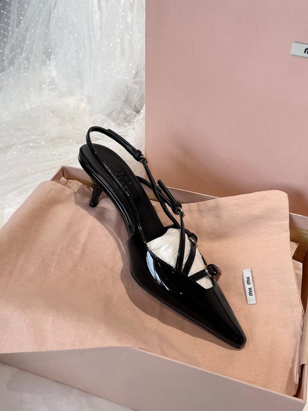 Sandale s kapom na prstima i stražnjim remenom; lakirana koža na gornjem dijelu s mašnicom; oštar vrh; uska peta 6–8 cm