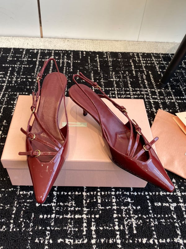 Sandale s kapom na prstima i stražnjim remenom; lakirana koža na gornjem dijelu s mašnicom; oštar vrh; uska peta 6–8 cm