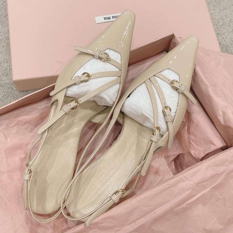 Sandale s kapom na prstima i stražnjim remenom; lakirana koža na gornjem dijelu s mašnicom; oštar vrh; uska peta 6–8 cm