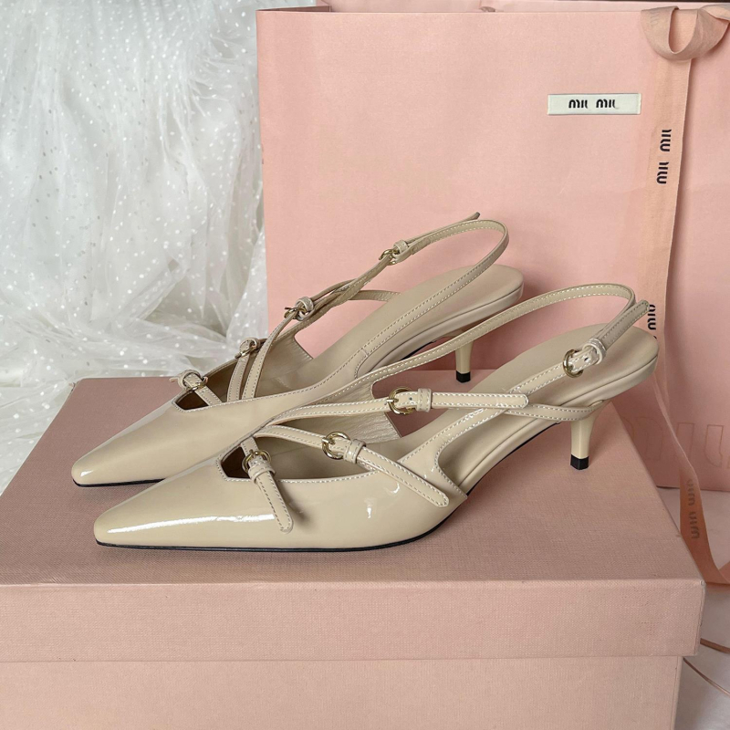 Sandale s kapom na prstima i stražnjim remenom; lakirana koža na gornjem dijelu s mašnicom; oštar vrh; uska peta 6–8 cm