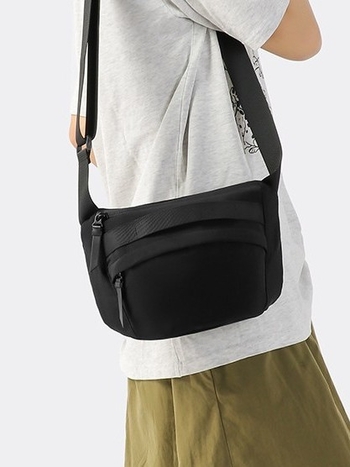 Unisex najlon crossbody torba sa zatvaračem, ovalni oblik, jednoručna naramenica, džep za telefon i dokumente.