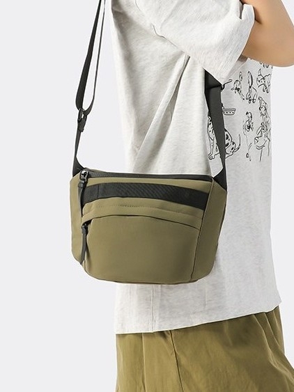 Unisex najlon crossbody torba sa zatvaračem, ovalni oblik, jednoručna naramenica, džep za telefon i dokumente.